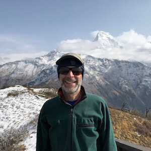 Elie, owner of Green Dream Cannabis Tours, smiling in front of the mountains of Nepal